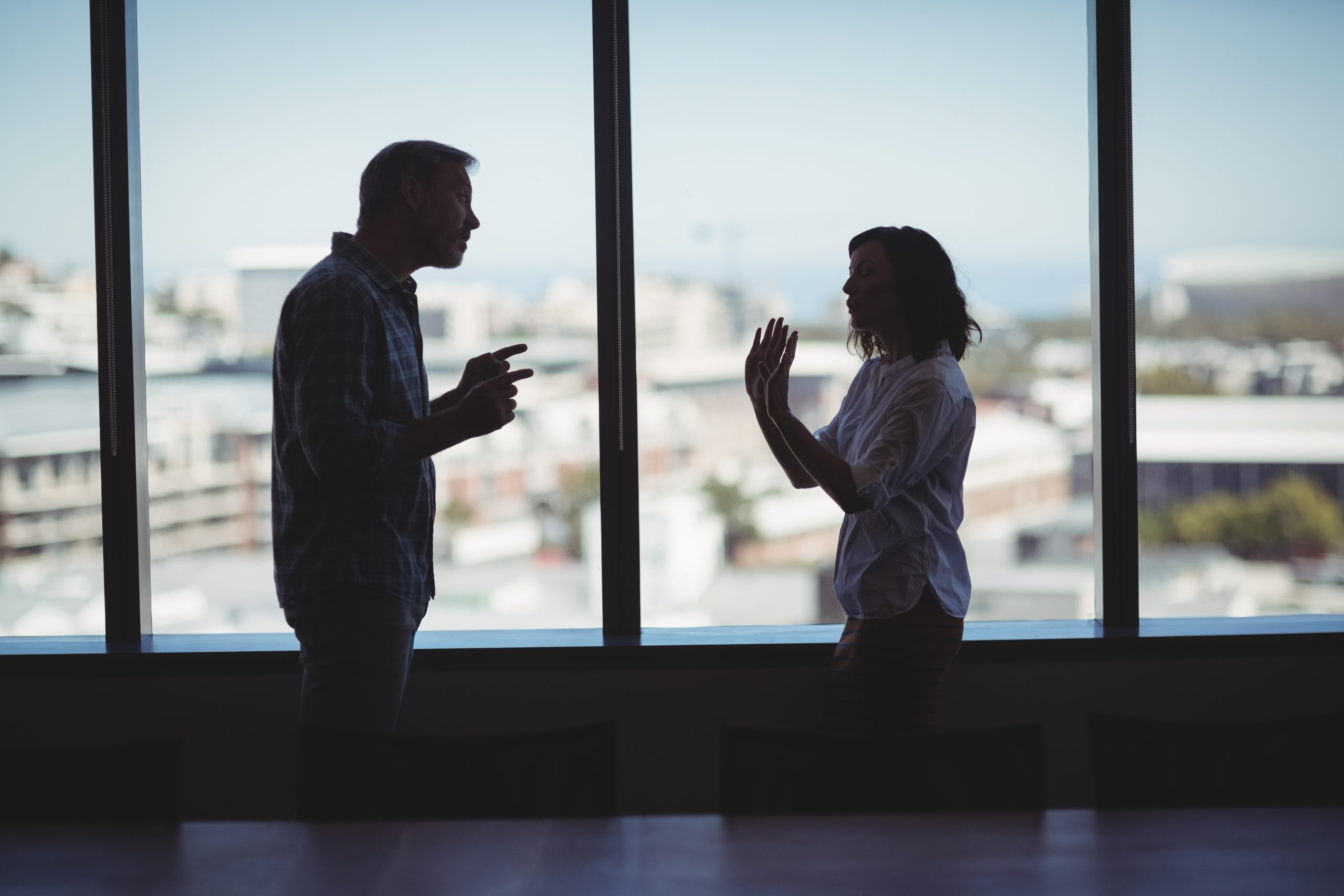 Business couple arguing near the window